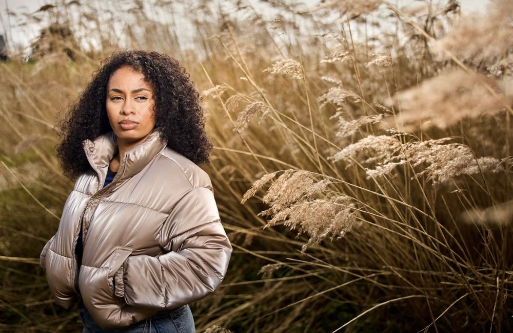 Zuellen buiten tussen hoog riet, in een glanzende jas, kijkt rechtdoor